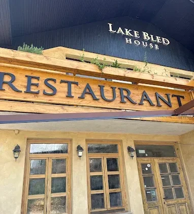 Pročelje restavracije Lake Bled House z lesenim napisom Restaurant na Grajski cesti